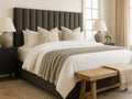 Neatly made Brit bed by Showhome Furniture with white bedding and charcoal headboard