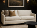 Lease sofa in Calgary with decorative pillows in a room with dark walls and a framed picture.