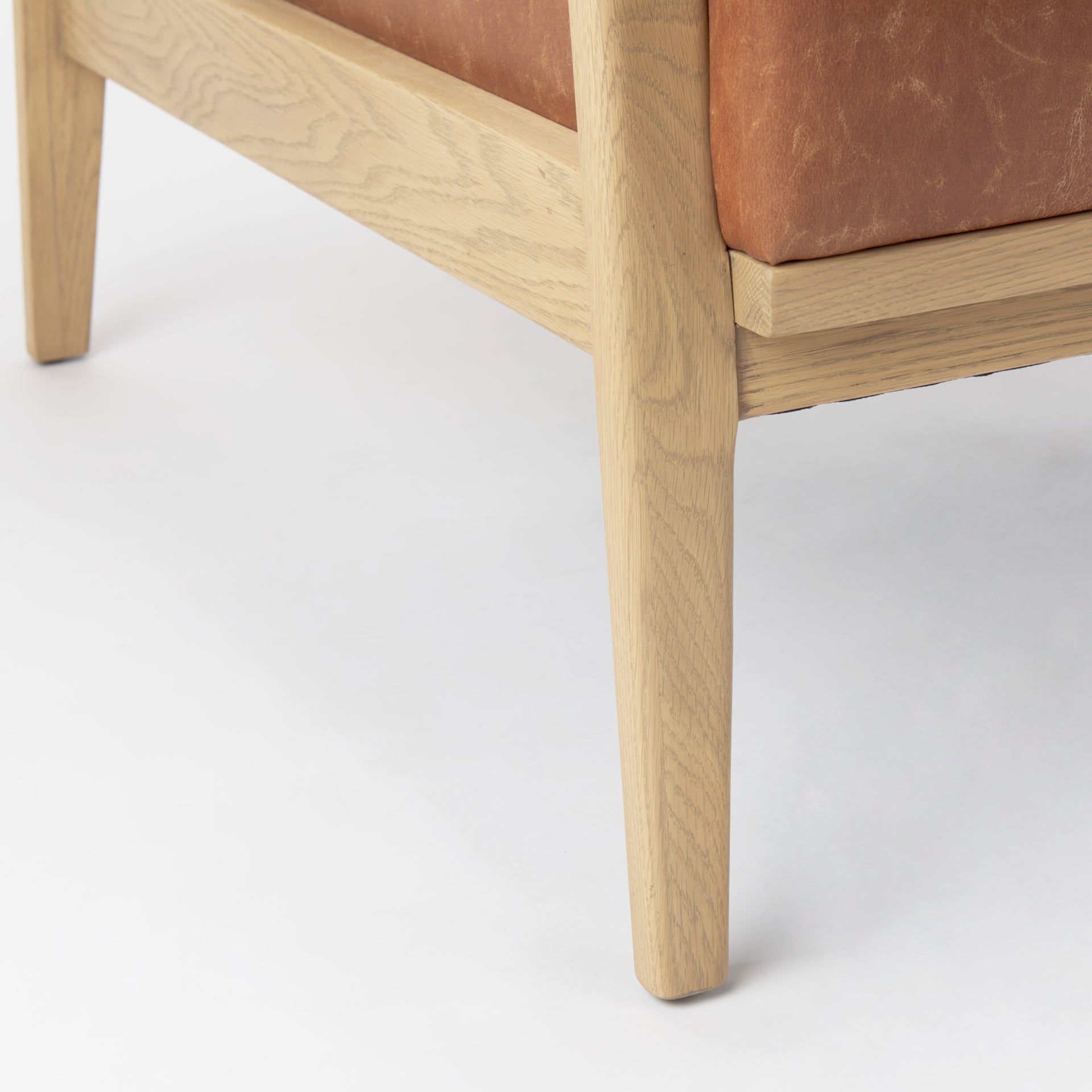 Close-up of Raeleigh Tan Faux Leather Accent Chair in Calgary with wooden frame