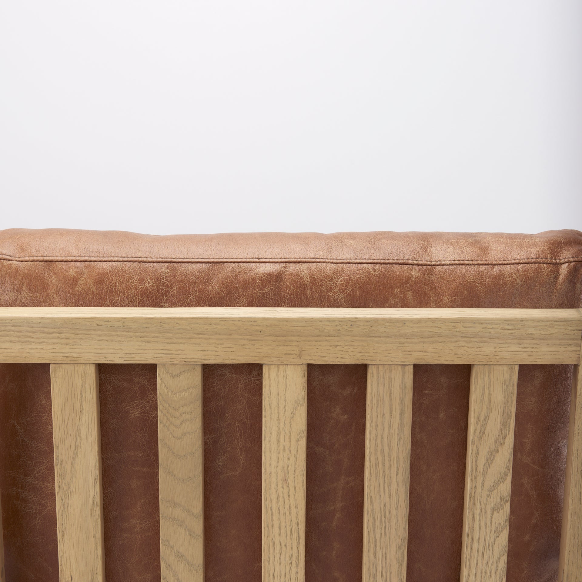 Close-up of Raeleigh Tan Faux Leather Accent Chair in Calgary with wooden frame