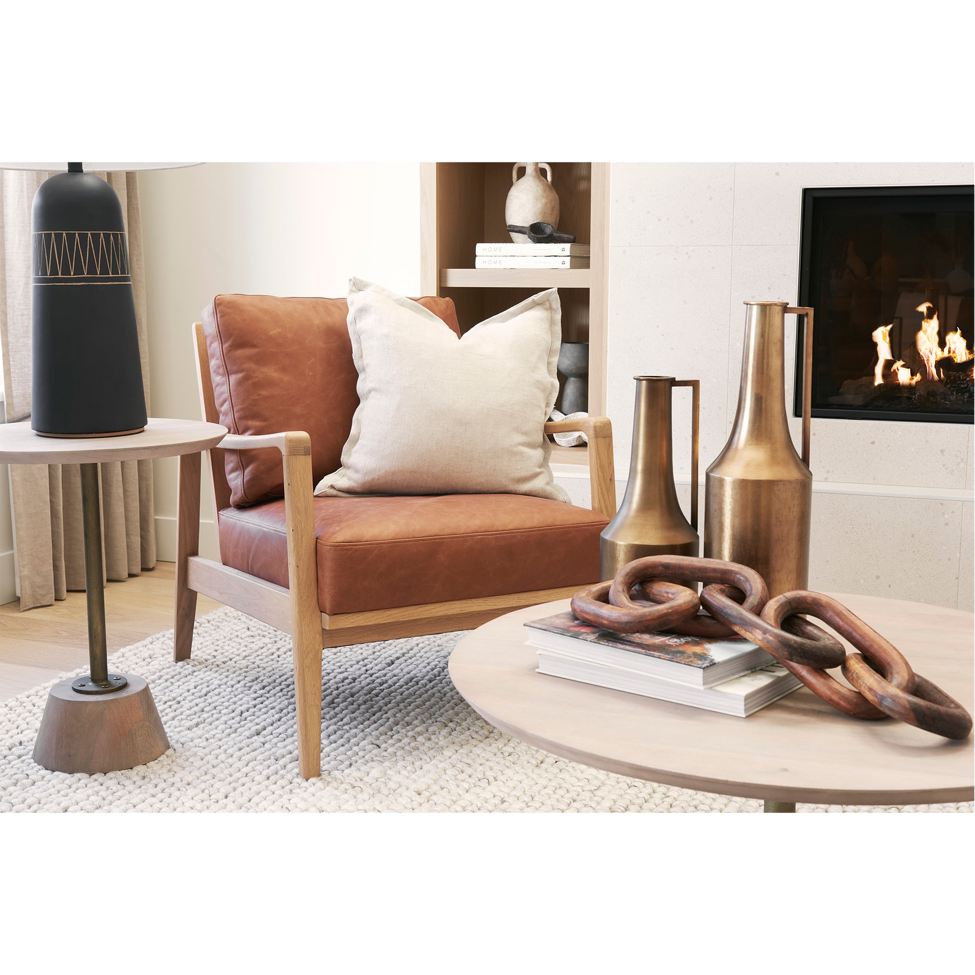 Modern living room with Close-up of Raeleigh Tan Faux Leather Accent Chair in Calgary with wooden frame, decorative table, and fireplace.