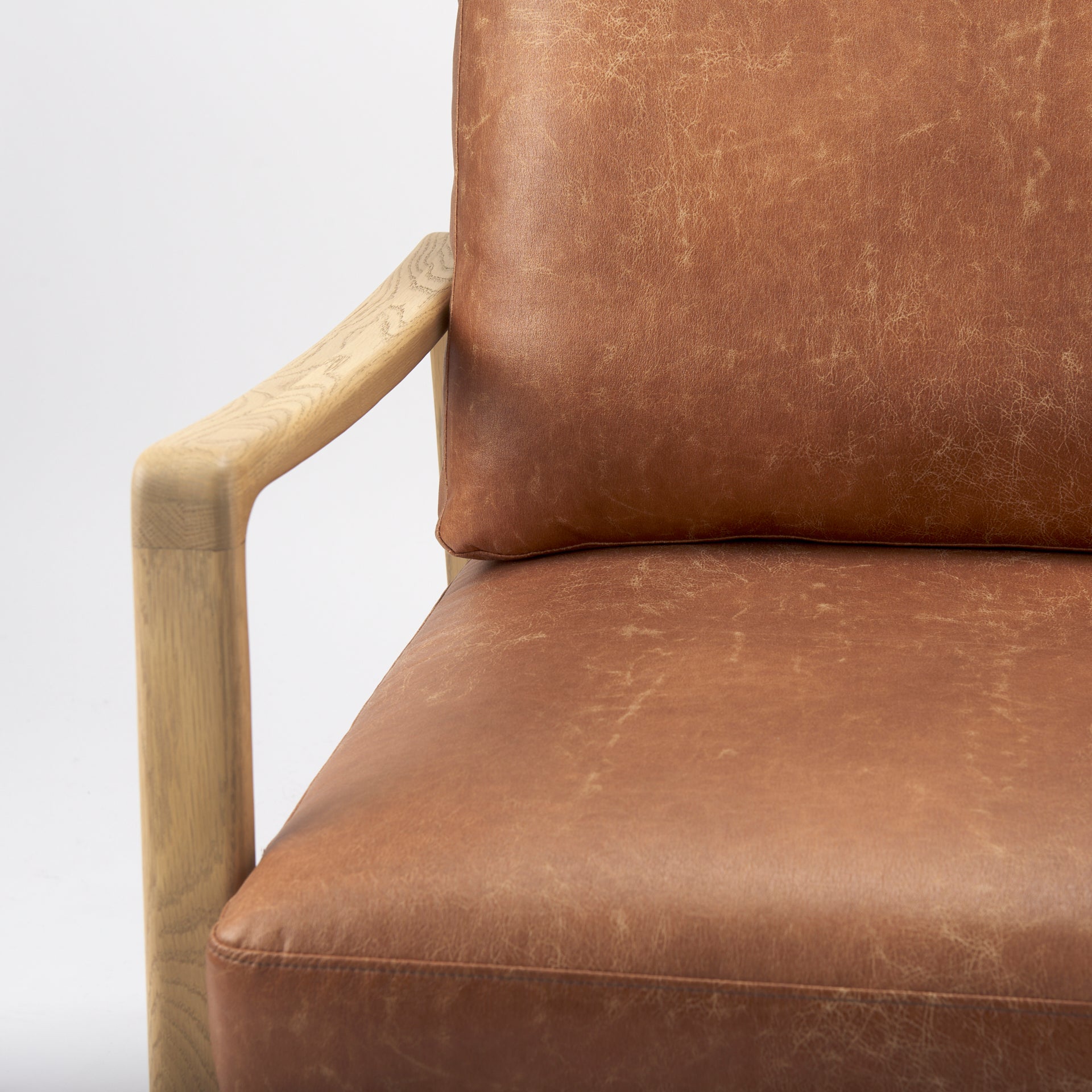 Close-up of Raeleigh Tan Faux Leather Accent Chair in Calgary with wooden frame