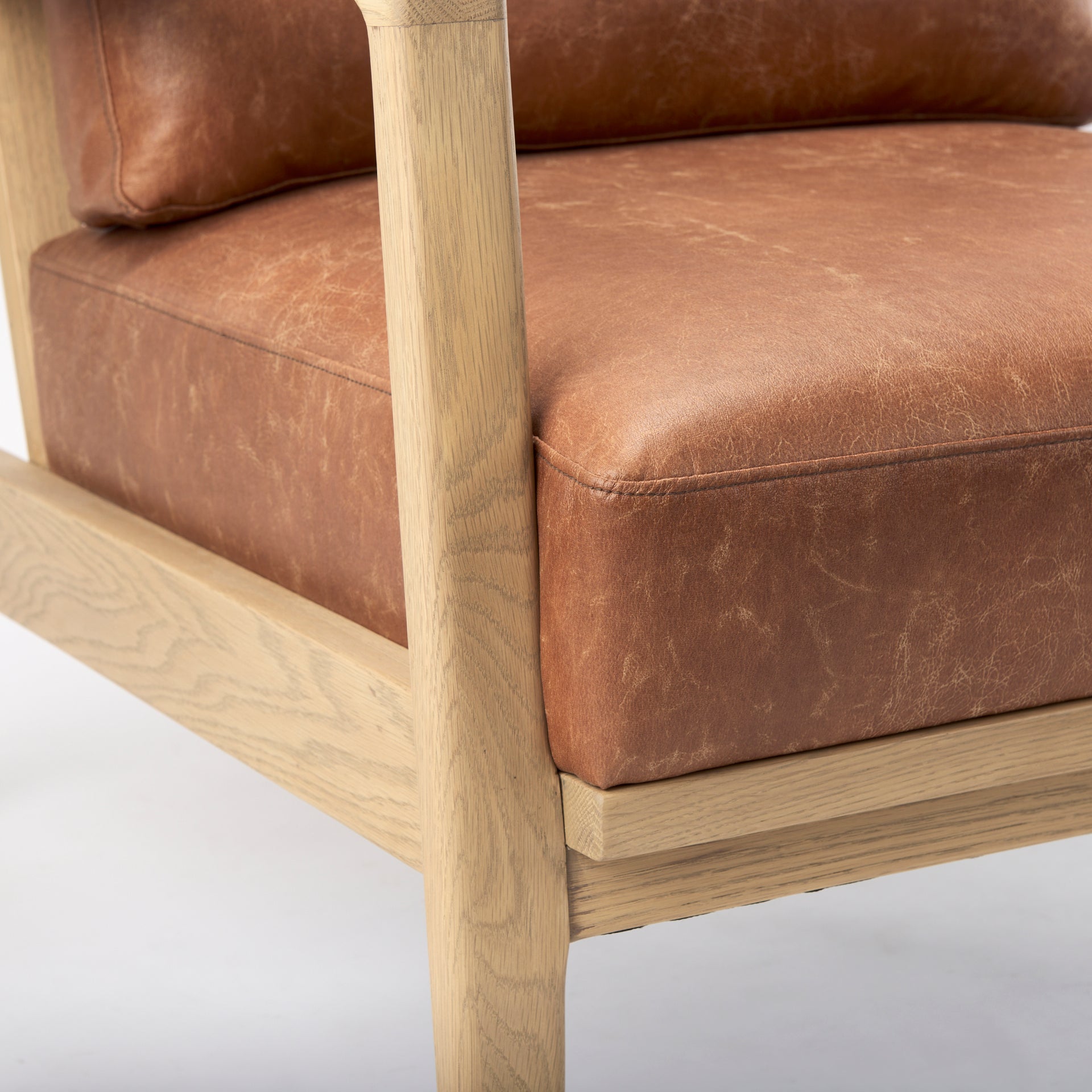 Close-up of Raeleigh Tan Faux Leather Accent Chair in Calgary with wooden frame