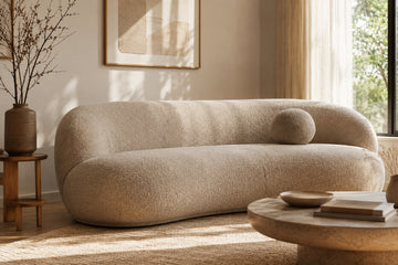 A deep, curved sofa in a warm minimalist Calgary living room