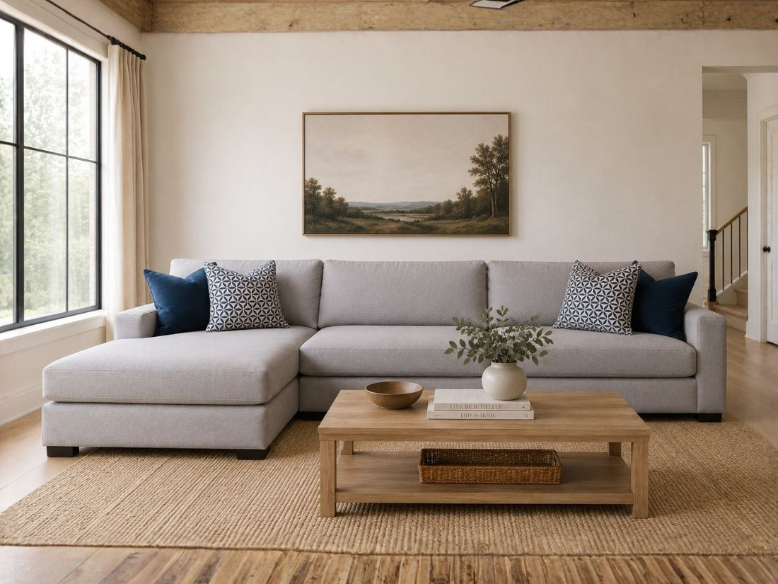Light gray fabric sectional with chaise and blue accent pillows in a cozy modern living room.