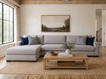 Light gray fabric sectional with chaise and blue accent pillows in a cozy modern living room.