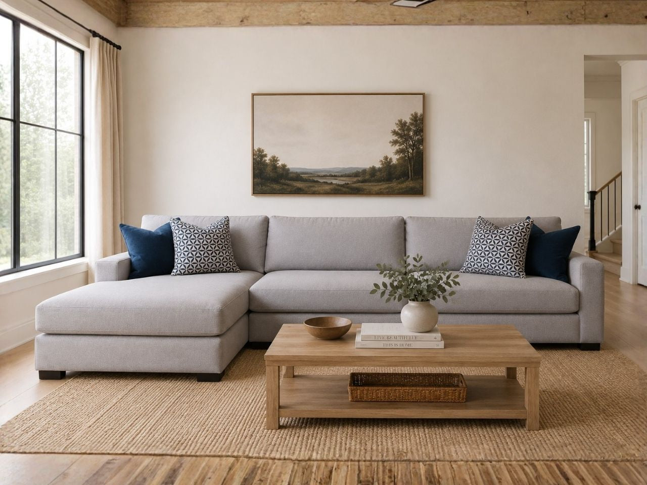 Light gray fabric sectional with chaise and blue accent pillows in a cozy modern living room.