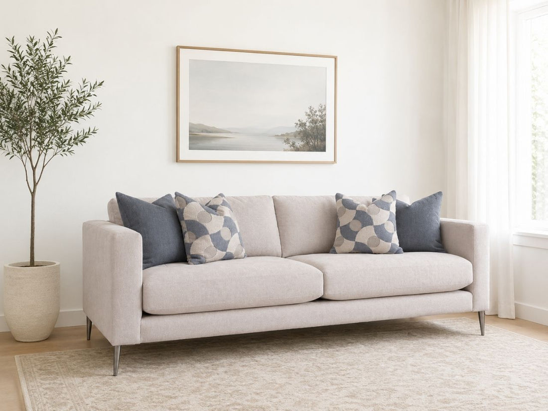 Light fabric sofa with blue accent pillows in a bright, modern living room.