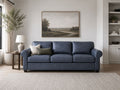 Blue leather sofa with accent pillows in a bright, modern living room.