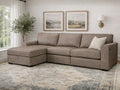 A taupe upholstered sectional sofa with a chaise in a bright, neutral living room.