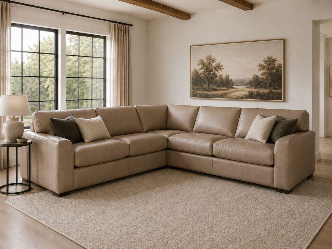 Tan leather sectional sofa with accent pillows in a bright, modern living room.