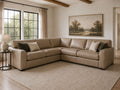 Tan leather sectional sofa with accent pillows in a bright, modern living room.