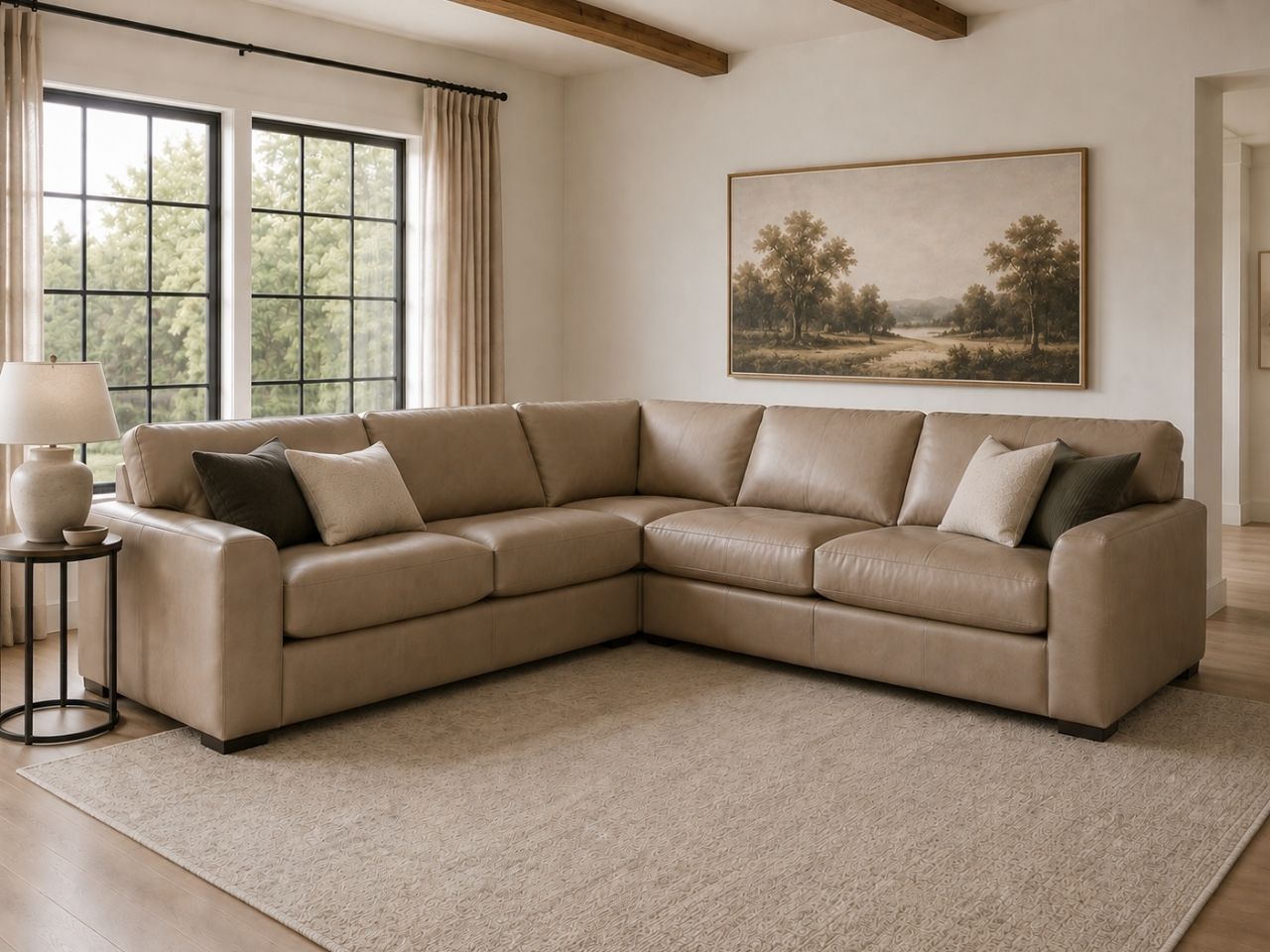 Tan leather sectional sofa with accent pillows in a bright, modern living room.