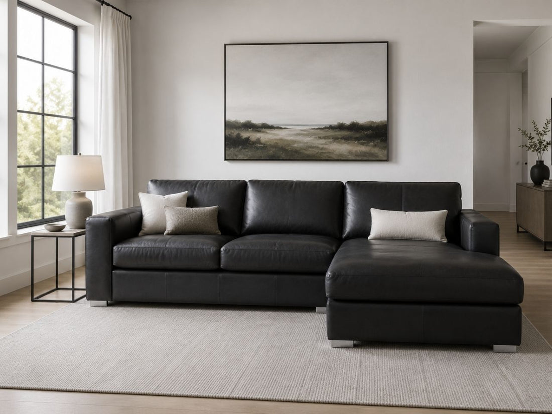 Black leather sectional sofa with chaise in a sleek, modern living room.