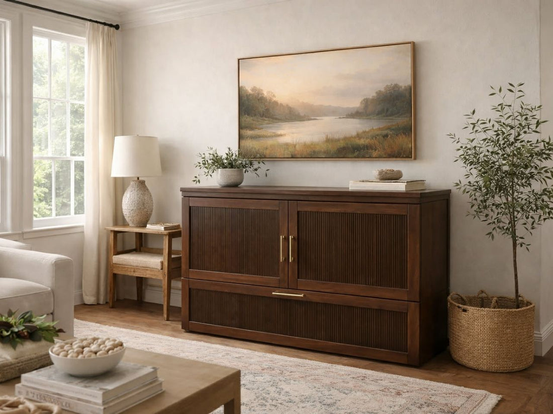 Light wood sideboard with paneled doors and brass hardware, styled in a bright, neutral living room.