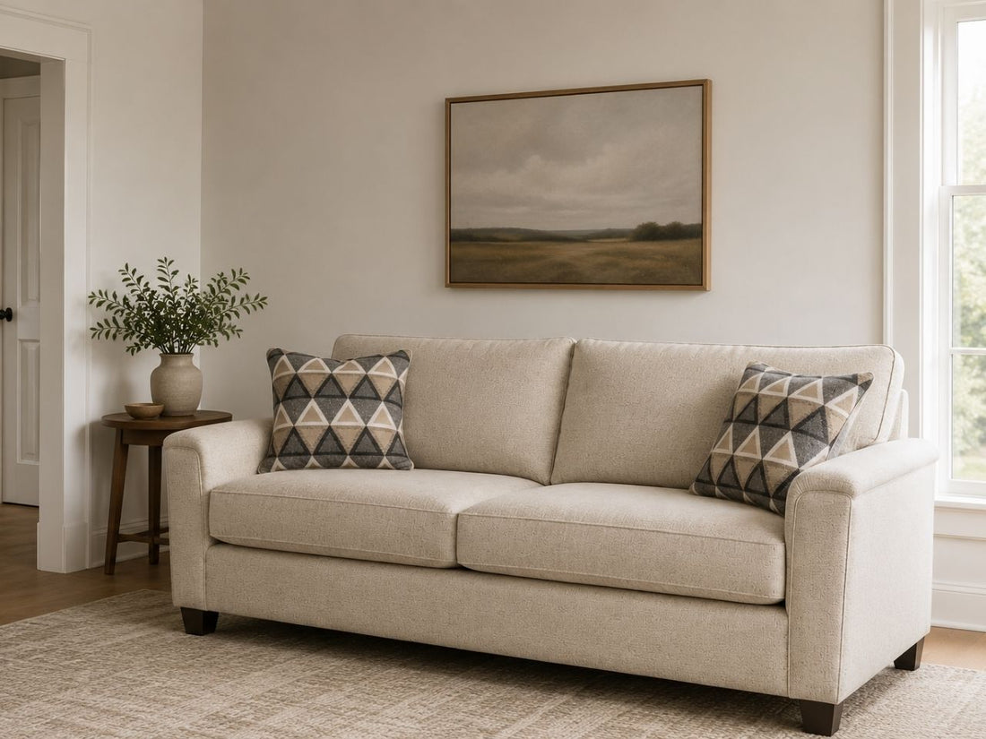 Light beige sofa with geometric accent pillows in a cozy, modern living room.