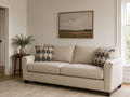 Light beige sofa with geometric accent pillows in a cozy, modern living room.