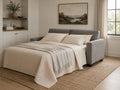 Gray sleeper sofa opened into a bed in a warm modern room.