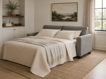 Gray sleeper sofa opened into a bed in a warm modern room.