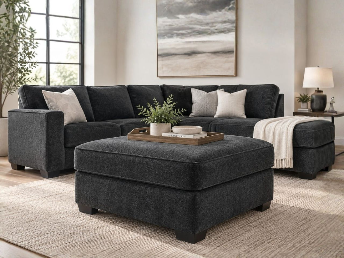 Charcoal grey upholstered ottoman with matching sectional sofa in a modern living room, featuring stylish ottoman furniture in Calgary and contemporary home décor.