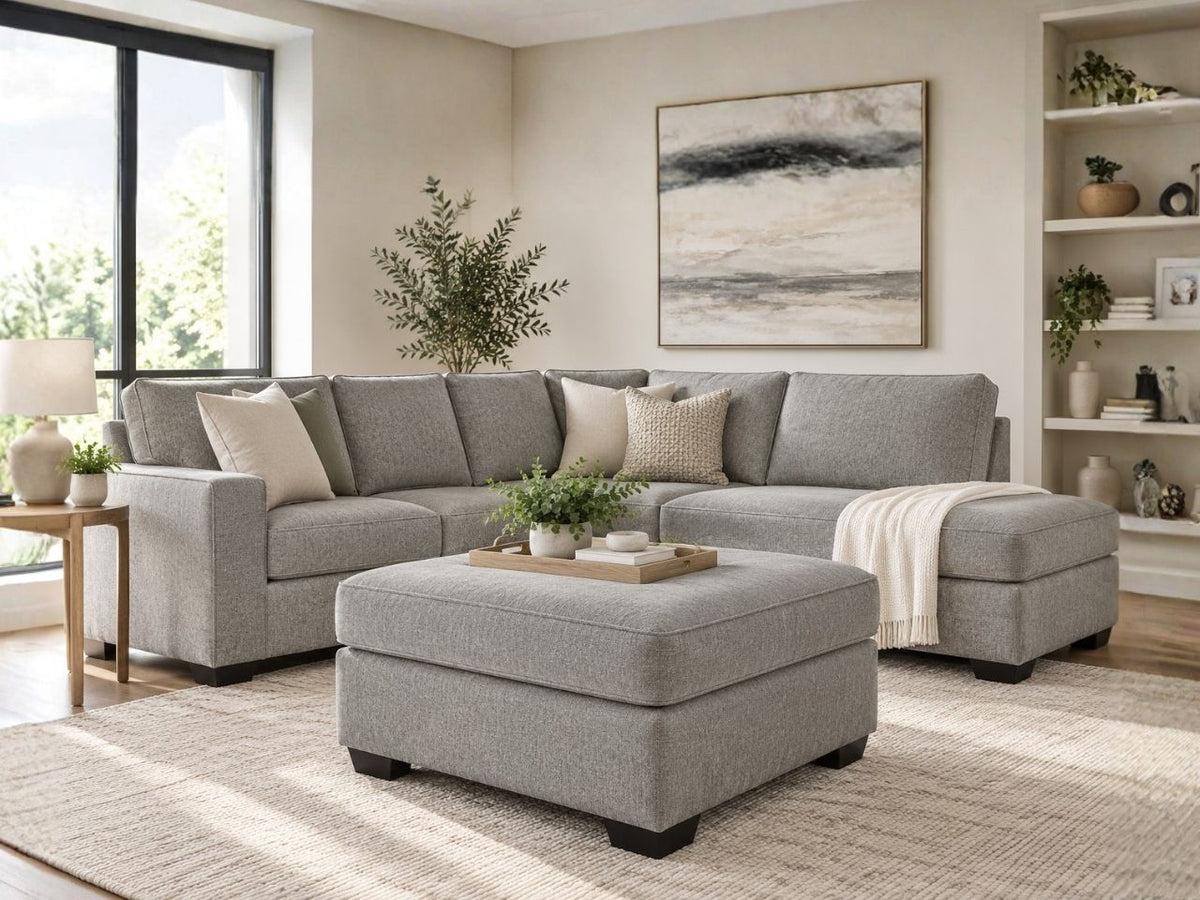 Light grey upholstered ottoman with matching sectional sofa in a bright modern living room, featuring stylish ottoman furniture in Calgary and contemporary home décor.