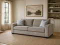 Light gray fabric sofa with accent pillows in a warm, modern living room.