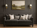 Gray sofabed in Calgary with decorative pillows in a room with a painting on the wall.