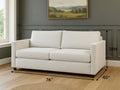 White sofabed in Calgary with dimensions marked on a wooden floor in a room with a painting on the wall.