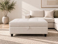 Cream tufted storage ottoman in a simple modern living room with neutral décor, soft natural light, and a cozy sectional.
