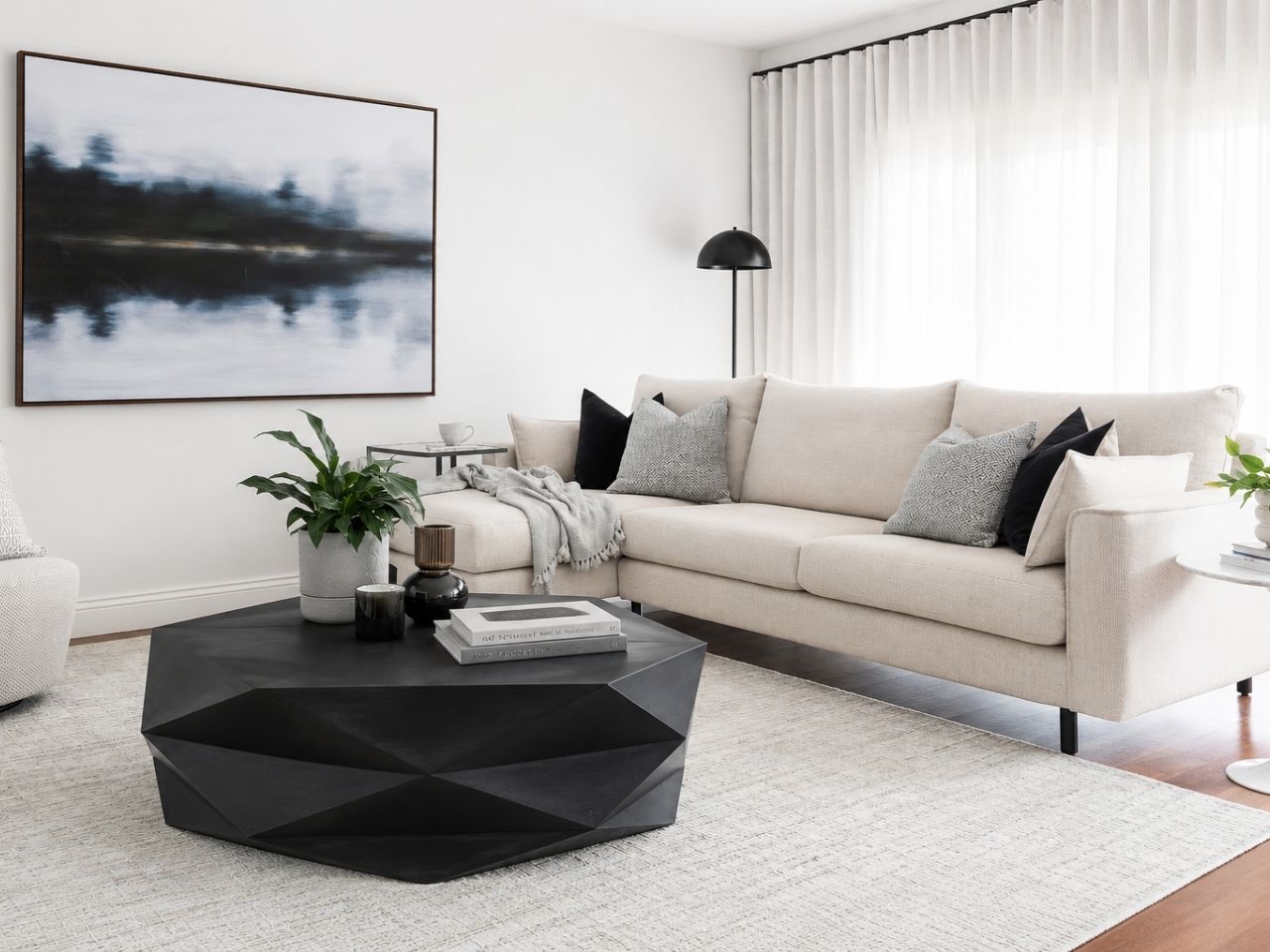 Black geometric coffee table styled in a modern living room with a light sofa and contemporary décor.