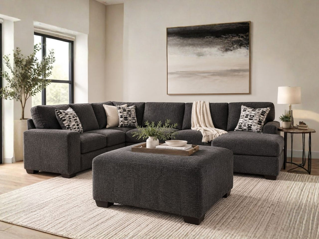 Charcoal grey upholstered ottoman with matching sectional sofa in a modern living room, featuring stylish ottoman furniture in Calgary and contemporary living room design.