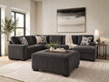 Charcoal grey upholstered ottoman with matching sectional sofa in a modern living room, featuring stylish ottoman furniture in Calgary and contemporary living room design.