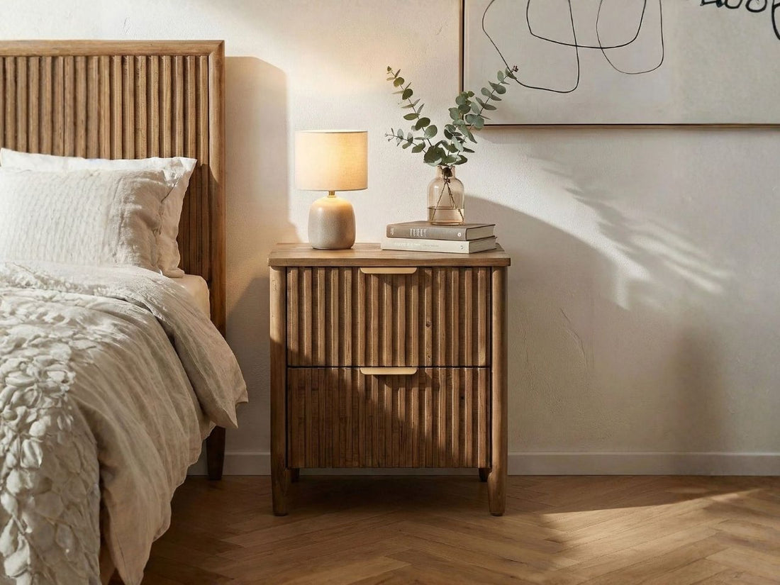Solid wood nightstand with fluted drawer fronts and brass-tone pulls.