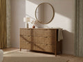 Solid wood six-drawer dresser with fluted fronts, styled beneath a round wall mirror.