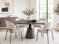 Round dark wood dining table with four cream upholstered chairs in a bright modern dining room.
