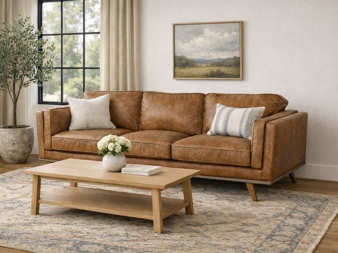 A brown leather sofa with clean lines in a bright, cozy living room.