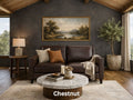 A compact two-cushion deep chocolate brown leather loveseat is featured against a dark charcoal-gray accent wall under a vaulted wood-plank ceiling. 