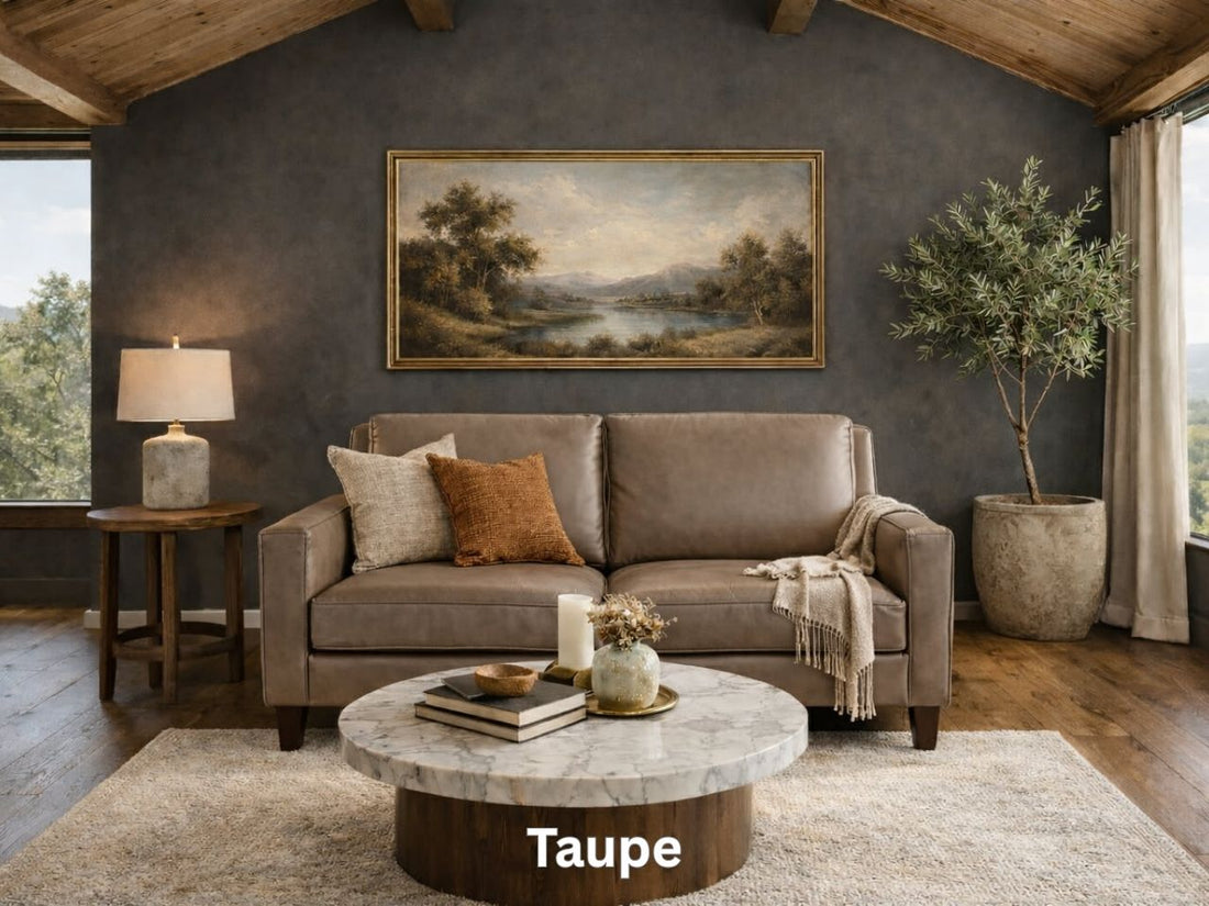 A compact two-cushion taupe leather loveseat sits in a moody living room with a dark gray accent wall and wood-plank ceilings.