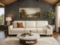 A three-cushion cream leather sofa labeled 'Vanilla' centered in a moody living room with a dark accent wall and marble coffee table.