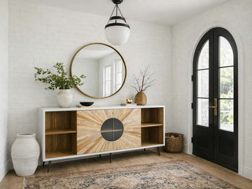  A modern sideboard with a white outer frame and light wood doors featuring a sunburst inlay pattern and a circular glass center.