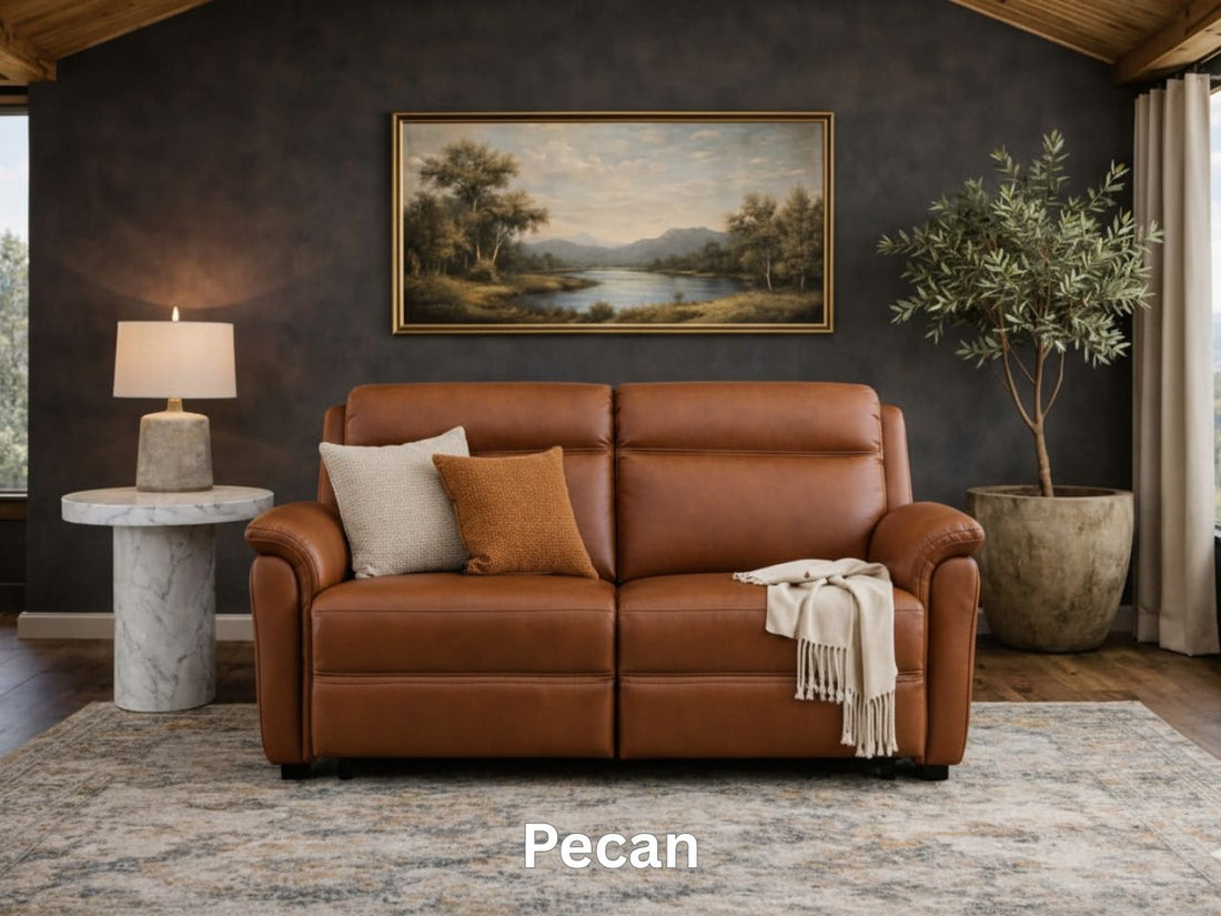 A bright cream leather sofa centered under a gold-framed landscape painting with a marble coffee table.