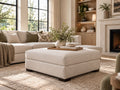 Cream upholstered ottoman in a bright, modern living room with warm neutral décor.