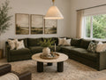An L-shaped Coastal sectional sofa upholstered in dark olive green fabric, styled in a cozy living room with beige and green patterned throw pillows.