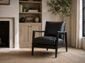 Black leather accent chair in a modern neutral living room.