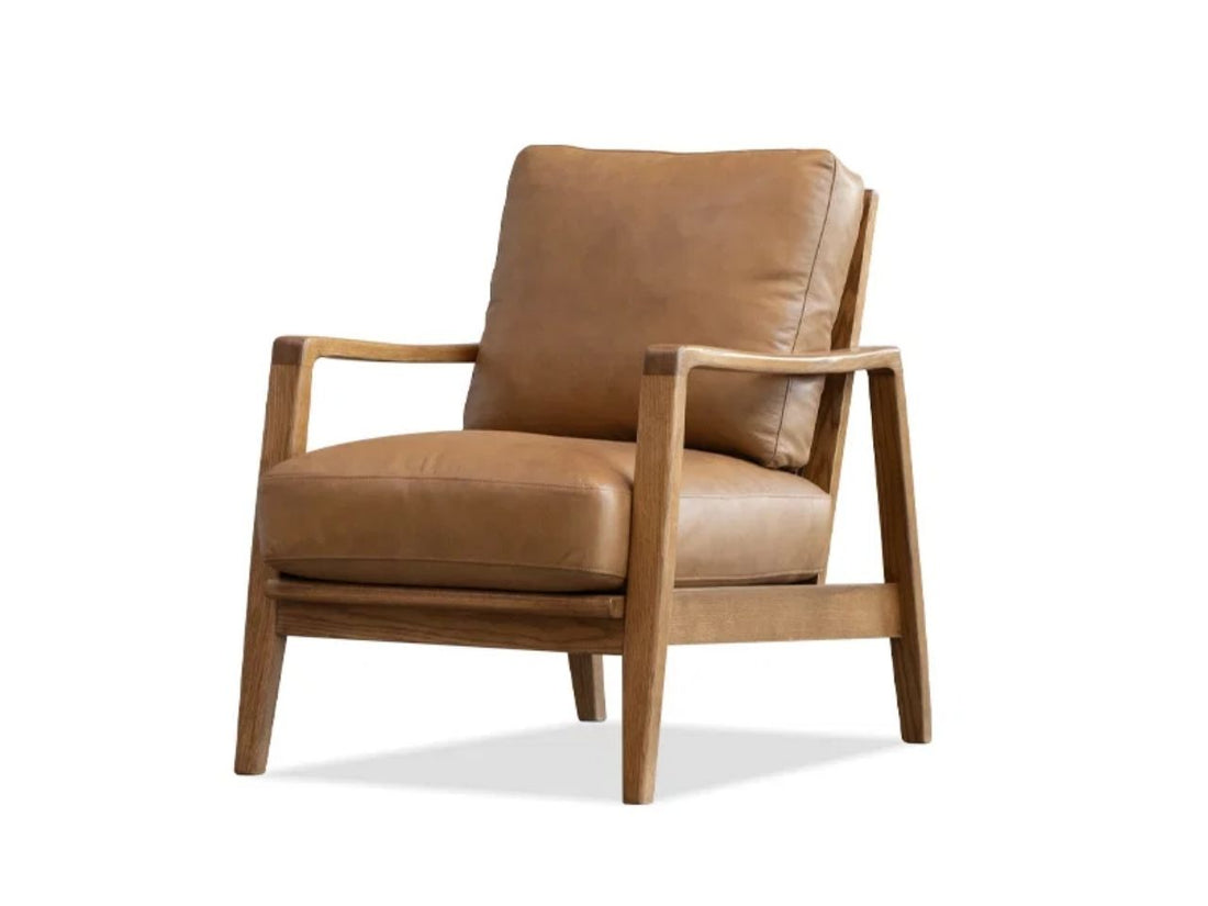 Tan leather accent chair with a wooden frame in a modern Calgary living room.