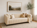 Cream upholstered sofa with channel tufting in a bright, elegant living room.