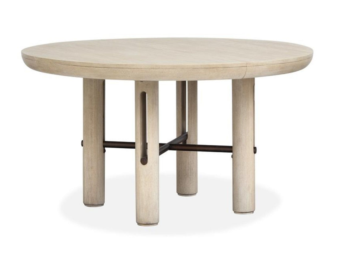 Light wood round extension dining table with upholstered chairs in a bright, neutral dining room.