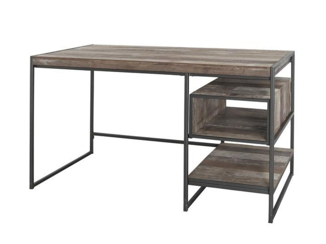 The Dandhi Multi-level Desk features a minimalist industrial design. It is constructed with a thick, rectangular tabletop made of textured wood with a weathered, multi-tonal brown finish.