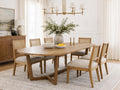 Light wood oval dining table with cane-back chairs in a bright dining room.