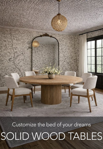 Dining room with a round wooden table and chairs, featuring a decorative wall and pendant lights.